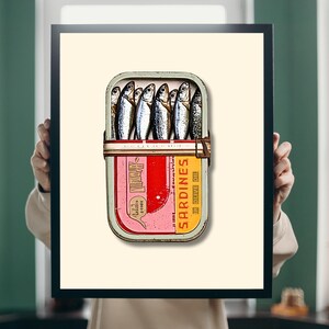 The soft beige background provides a neutral backdrop that enhances the vivid red and yellow hues of the tin. The silvery sardines and muted green rim further balance the composition, creating a visually appealing contrast.