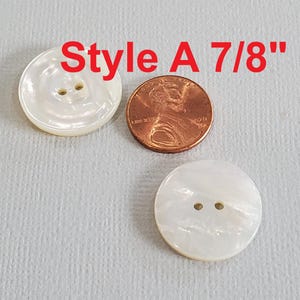 May include: Two white, round buttons with two holes each, next to a penny. The buttons are labeled "Style A 7/8"" in red text.