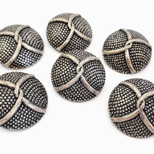 May include: Six silver-toned buttons with a raised, woven design and a textured surface.