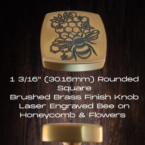 May include: Brushed brass finish knob with a laser-engraved bee on a honeycomb and flowers design. The knob is a 1 3/16" rounded square. A second knob with a rounded top and a brass finish is also shown.