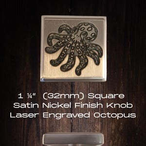 May include: A square satin nickel finish knob with a laser-engraved octopus design. The knob measures 1 1/4 inches (32mm) square. The image also shows the knob's handle. The text on the image reads: "1 1/4" (32mm) Square Satin Nickel Finish Knob Laser Engraved Octopus."