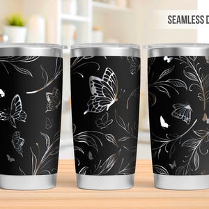May include: Three stainless steel tumblers with a black background and a silver butterfly and floral design. The design is seamless and repeats around the tumblers.