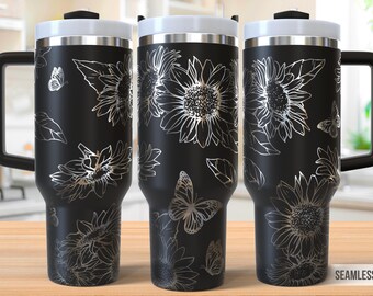 Op de afbeelding: Zwarte reistumbler van roestvrij staal met een wit deksel en handvat. De tumbler heeft een zilveren ontwerp met zonnebloemen en vlinders.