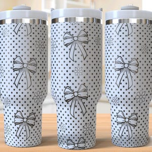 Pode incluir: Três copos de aço inoxidável com fundo branco e bolinhas pretas e desenhos de laços. Os copos têm uma alça e uma tampa. O texto "SEAMLESS DESIGN" é visível no canto inferior direito da imagem.