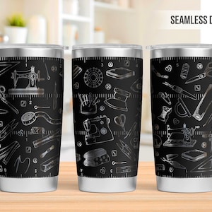 Peut inclure: Trois gobelets en acier inoxydable avec un fond noir et des illustrations blanches d'outils et de fournitures de couture. Les gobelets présentent un motif sans couture avec un motif répétitif de machines à coudre, de ciseaux, de règles, de fils, de boutons et de tissus.