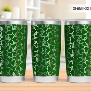May include: Three stainless steel tumblers with a green and white shamrock pattern. The tumblers are seamless and have a silver lid.