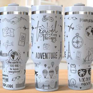May include: Three white travel mugs with black and gray designs. The mugs feature various travel-themed illustrations, including airplanes, hot air balloons, a compass, and the Eiffel Tower. The text on the mugs reads "Discover", "Travel is my Therapy", and "Memories".