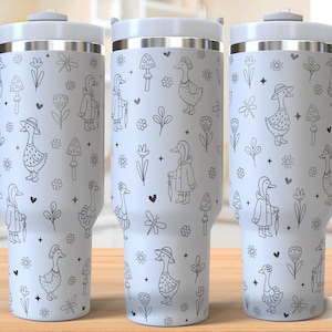 May include: Three white travel mugs with a whimsical black and white goose pattern. The mugs have a handle, a lid, and a silver band. The design includes geese, mushrooms, flowers, and hearts. The text "SEAMLESS DESIGN" is at the bottom right.
