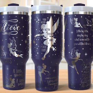 May include: Three stainless steel tumblers with a dark blue finish and silver glitter accents. The tumblers feature a fairy silhouette and inspirational quotes, including "All you need is faith, trust, and pixie dust" and "Believe in happy thoughts".