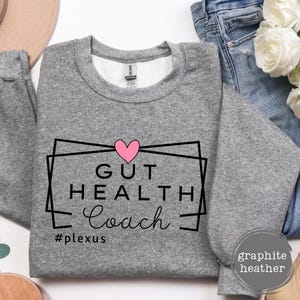 May include: Gray sweatshirt with a black graphic that says "Gut Health Coach" with a pink heart and the hashtag "#plexus".