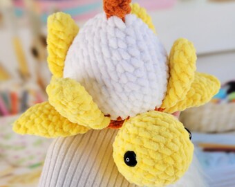May include: A handmade crochet turtle in yellow, white, and orange. The turtle has a yellow head and flippers, a white shell, and an orange stem. The text "PATTERN PDF" is visible at the bottom of the image.