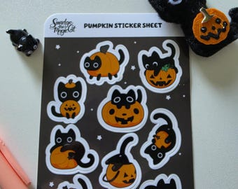 May include: A rectangular sticker sheet titled PUMPKIN STICKER SHEET featuring Smudge the Magic Cat branding. The sheet contains nine individual stickers of black cats interacting with orange pumpkins against a dark brown background with white stars.