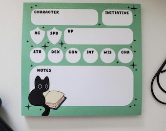 May include: A square, pale green notepad with black text and a black cat illustration. The notepad has sections for character stats, initiative, and notes. The cat is reading a book. The notepad is decorated with small star accents.