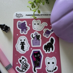 May include: A rectangular sticker sheet with a dark pink background featuring various cat-themed illustrations, including ghosts, a skeleton cat, a cat in a coffin, and a tombstone with the text RIP. The header reads Smudge the Magic Cat PURRANORMAL STICKER SHEET.
