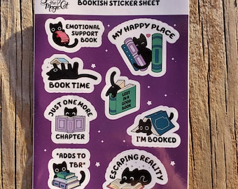 May include: A purple sticker sheet with illustrations of black cats and books. Text includes "Bookish Sticker Sheet," "My Happy Place," and "I'm Booked." The brand name "Smudge the Magic Cat" is at the top left corner of the sheet.