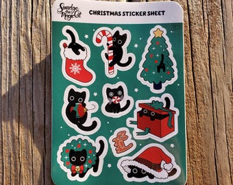 May include: A festive Christmas sticker sheet with black cat designs. The stickers depict cats in various holiday settings, such as a stocking, with a candy cane, and decorating a Christmas tree. Also included are a cat in a gift box and wearing a Santa hat.