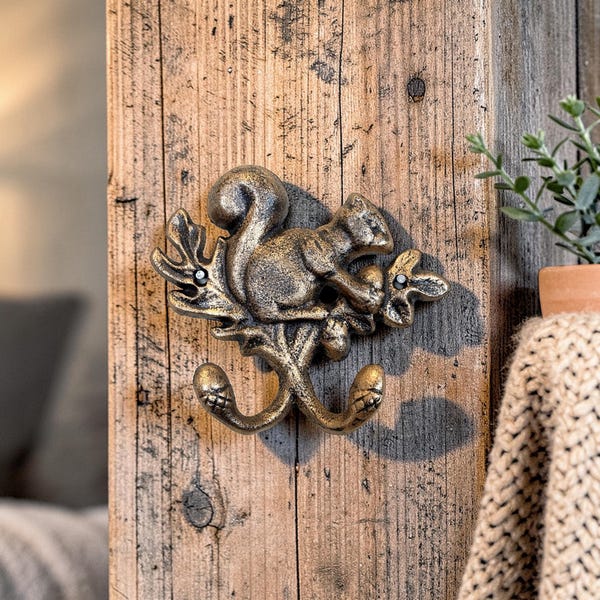 Perchero de hierro fundido pintado a mano con forma de llave de ardilla y ganchos en forma de bellota.