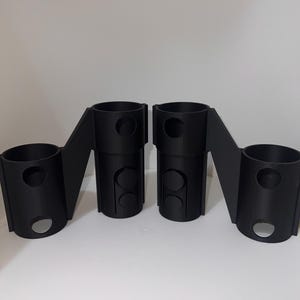 K&ouml;nnte beinhalten: Zwei schwarze, 3D-gedruckte Kunststoffteile mit mehreren L&ouml;chern. Die Teile sind so konzipiert, dass sie miteinander verbunden werden k&ouml;nnen.