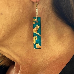 Pendientes colgantes de monolito en un azul pavo real intenso con glamorosos detalles en escamas de oro rosa: transforma tu llamativo atuendo sin esfuerzo.