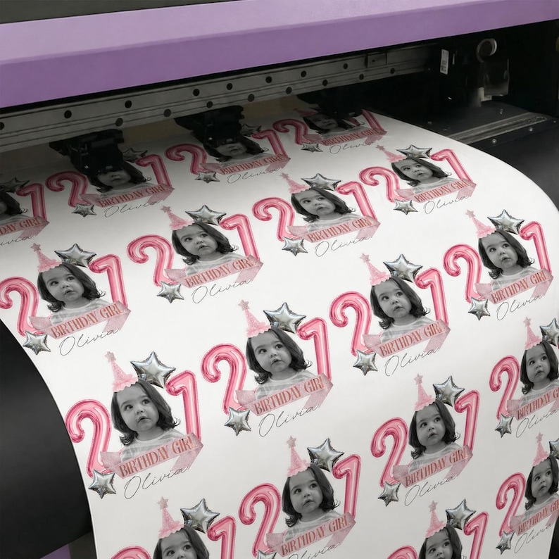 May include: A sheet of printed stickers featuring a young girl's photo, the number 2, and the text "Birthday Girl Olivia." The stickers have a pink and silver color scheme, with star and balloon accents. The stickers are printed on a white background.