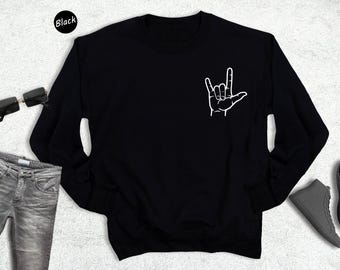May include: Black sweatshirt with a white hand sign that says "I love you" in American Sign Language.
