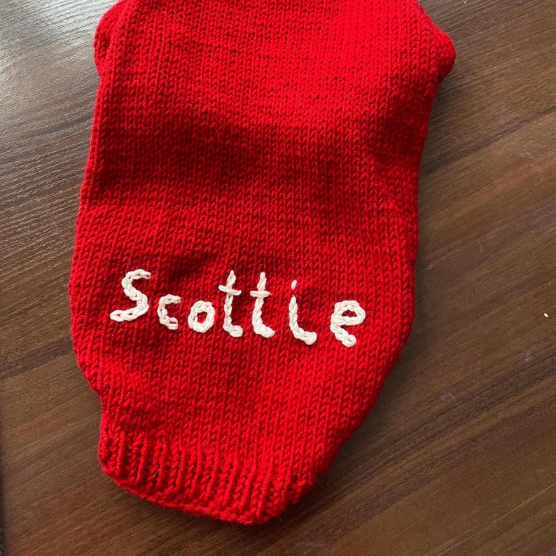 Pu&ograve; includere: Un capo in maglia rosso brillante con il nome Scottie ricamato in filo bianco sul davanti. Il pezzo &egrave; realizzato con una lavorazione a maglia rasata standard e include un dettaglio con orlo a coste sul bordo inferiore del tessuto.