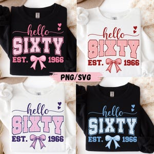 May include: Four sweatshirts with the text "hello SIXTY EST. 1966" in various colors. The text is in a script font with a bow and hearts. The sweatshirts are black, white, and the text is pink and blue.