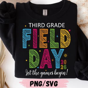 Puede incluir: Sudadera negra con el texto "THIRD GRADE FIELD DAY" en letras de colores. La frase "Let the games begin!" está debajo del texto principal, con el año "2026". La parte inferior de la imagen dice "PNG/SVG".