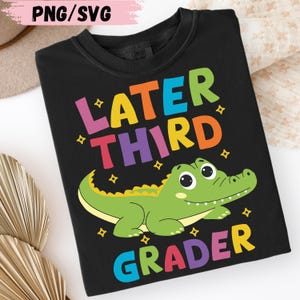 Könnte beinhalten: Schwarzes T-Shirt mit dem Text "LATER THIRD GRADER" in bunten Buchstaben. Unter dem Text ist ein grüner Cartoon-Alligator abgebildet. Das Shirt ist von der Marke Comfort Colors.