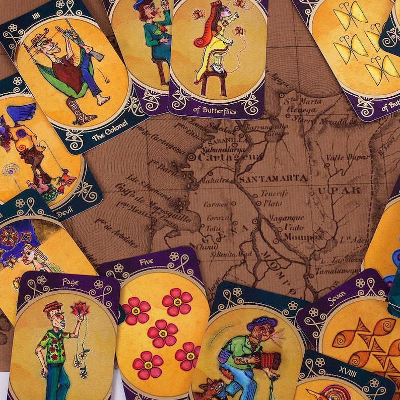 Op de afbeelding: Een set tarotkaarten met kleurrijke illustraties en gouden accenten. De kaarten bevatten een verscheidenheid aan personages en symbolen, waaronder een vlinder, een kolonel, een duivel, een page, een vijf, een zeven en een XVIII. De kaarten liggen op een kaart met de namen van verschillende locaties.