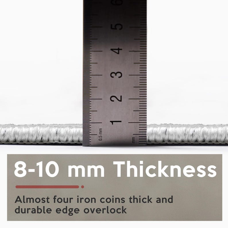 K&ouml;nnte beinhalten: Nahaufnahme eines hellgrauen Teppichs mit einem Lineal, das eine Dicke von 8-10 mm anzeigt. Der Text auf dem Bild lautet "8-10 mm Thickness" und "Almost four iron coins thick and durable edge overlock."