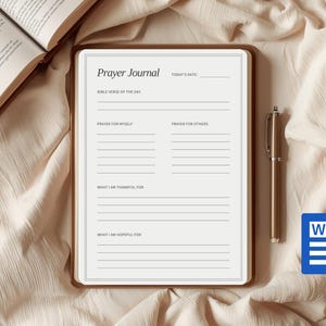 May include: A beige prayer journal with the title "Prayer Journal" and lined sections for Bible verses, prayers, and gratitude. A gold pen and a Word document icon are next to the journal. An open book is in the background.