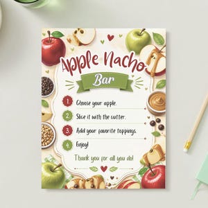 May include: A rectangular sign titled Apple Nacho Bar with a green banner and numbered instructions: 1. Choose your apple. 2. Slice it with the cutter. 3. Add your favorite toppings. 4. Enjoy! The text Thank you for all you do is at the bottom.