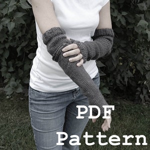 May include: A PDF pattern for knitting gray fingerless gloves. The pattern is shown on a model wearing the gloves with a white t-shirt and blue jeans.