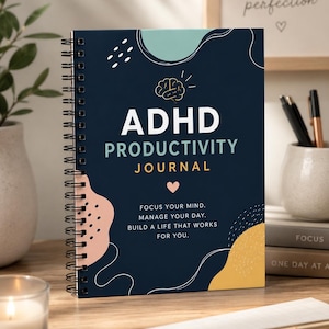 Könnte beinhalten: Ein spiralgebundenes ADHD-Produktivitätstagebuch mit marineblauem Einband. Der Einband zeigt die Worte "ADHD PRODUCTIVITY JOURNAL" in Weiß, mit einer Gehirngrafik und dem Text "Konzentriere dich. Verwalte deinen Tag. Baue ein Leben auf, das für dich funktioniert."