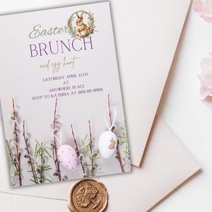 Op de afbeelding: Een lichtpaarse uitnodigingskaart met een gouden en witte aankondiging voor een paasbrunch en eierenjacht. De kaart heeft een illustratie van een konijn en een krans van bloemen. De tekst luidt "Paasbrunch en eierenjacht, zaterdag 15 april in Anywhere Place, RSVP aan Katrina op 888-88-8888".