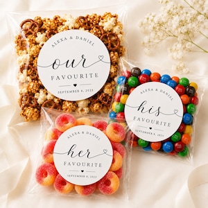 May include: Three clear plastic bags filled with snacks, each featuring a round white label. One bag contains popcorn and pretzels labelled 'our FAVOURITE', one has colourful chocolate candies labelled 'his FAVOURITE', and one has peach rings labelled 'her FAVOURITE'. All labels include 'ALEXA & DANIEL' and 'SEPTEMBER 8, 2025'.
