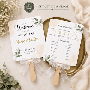May include: Two wedding programme fans with rounded corners, featuring white cardstock with watercolour greenery and tan accents. Each fan has a wooden handle and a white sheer ribbon bow. The text includes Welcome to our Wedding, Marie & Dillon, and a Wedding Timeline.