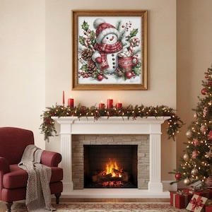 May include: A framed watercolor print of a snowman wearing a red and white hat and scarf, holding a mug of hot cocoa. The print is displayed above a fireplace decorated with garland and candles, with a Christmas tree to the right.