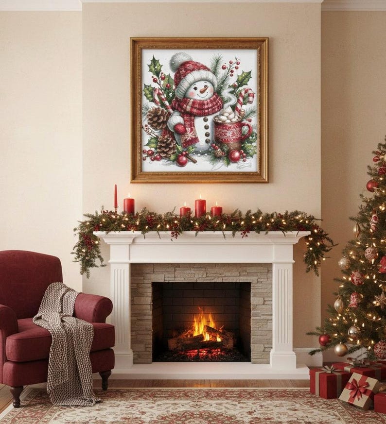 May include: A framed watercolor print of a snowman wearing a red and white hat and scarf, holding a mug of hot cocoa. The print is displayed above a fireplace decorated with garland and candles, with a Christmas tree to the right.