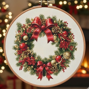 May include: A cross-stitch Christmas wreath in a wooden embroidery hoop. The wreath features red bows, berries, ornaments, and pinecones. Green pine needles and gold accents complete the festive design, perfect for holiday decor.