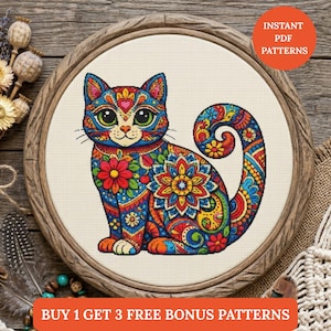 May include: A colorful cross-stitch pattern of a cat with intricate floral and geometric designs in a wooden embroidery hoop. The cat features a heart on its forehead and a curled tail. The text "INSTANT PDF PATTERNS" is visible.