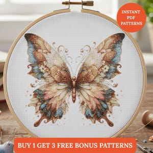 Puede incluir: Un diseño de mariposa de punto de cruz en un bastidor de bordado de madera. La mariposa presenta tonos marrones, azules y rosas con detalles intrincados. El texto "INSTANT PDF PATTERNS" y "BUY 1 GET 3 FREE BONUS PATTERNS" son visibles.