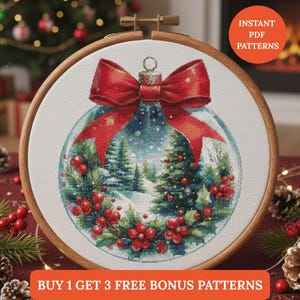 Può includere: Un modello a punto croce in un telaio di legno presenta un design a forma di ornamento natalizio. L'ornamento ha un fiocco rosso, una scena di foresta innevata e bacche rosse. Il testo "INSTANT PDF PATTERNS" e "BUY 1 GET 3 FREE BONUS PATTERNS" sono visibili.