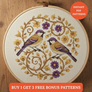 Könnte beinhalten: Ein Kreuzstich-Stickrahmen mit zwei Vögeln auf einem Ast, umgeben von floralen und Blattmustern. Die Vögel sind lila und beige gefärbt. Der Text "INSTANT PDF PATTERNS" befindet sich in einem Kreis. Der Text "BUY 1 GET 3 FREE BONUS PATTERNS" steht unten.