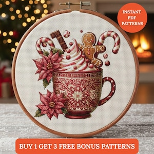 Peut inclure: Broderie au point de croix dans un cercle en bois avec un motif de vacances festif. Une tasse rouge est remplie de crème fouettée, de cannes en bonbon et d'un bonhomme en pain d'épices. Le motif comprend des poinsettias et le texte "Instant PDF Patterns".