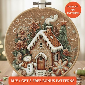 May include: A cross-stitch embroidery hoop with a festive winter design. It depicts a gingerbread house, snowman, and falling snow. The roof is covered in snow. Text includes "Instant PDF Patterns" and "Buy 1 Get 3 Free Bonus Patterns".