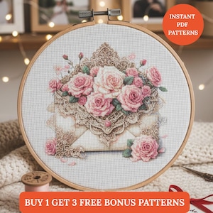Puede incluir: Bordado de punto de cruz en un aro de madera con un diseño floral de rosas rosas y crema. El diseño está sobre un fondo blanco e incluye un sobre adornado. El texto dice "Instant PDF Patterns" y "Buy 1 Get 3 Free Bonus Patterns."