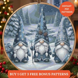 Puede incluir: Un patrón de punto de cruz con tres gnomos en una escena invernal nevada, enmarcado en un aro de madera. Los gnomos visten abrigos y sombreros azules con detalles de copos de nieve y piñas. El texto "INSTANT PDF PATTERNS" y "BUY 1 GET 3 FREE BONUS PATTERNS" es visible.
