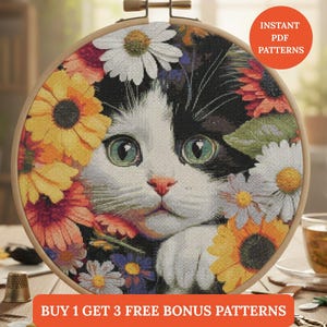 Puede incluir: Un patrón de punto de cruz de un gato con ojos verdes, rodeado de flores coloridas, en un bastidor de bordado de madera. El gato tiene pelaje blanco y negro. El texto en la imagen dice "Instant PDF Patterns" y "Buy 1 Get 3 Free Bonus Patterns."